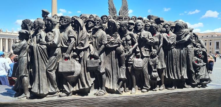 La escultura en la Plaza de San Pedro dedicada a los inmigrantes se llama 'Angels Unaware' (Ángeles sin saberlo). Esta escultura, de bronce y con 6 metros de altura, representa a 140 migrantes y refugiados. Fue creada por el artista canadiense Timothy Paul Schmalz y fue inaugurada por el Papa Francisco.