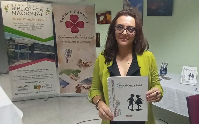 Natalia Esquivel Benítez muestra el libro impreso de la Suite Guitarra Social, obra presentada el 28 de enero en la Benemérita Biblioteca Nacional de Costa Rica.