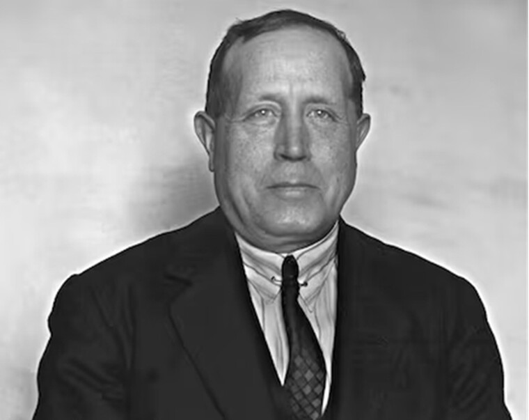 Fotografía de Azorín, tomada a mediados de la década de 1920. Retrato frontal en blanco y negro del escritor en su madurez (con poco más de 50 años). Viste de manera pulcra y formal con un traje oscuro, camisa de cuello rígido alto y una corbata oscura estampada con un sutil patrón geométrico
