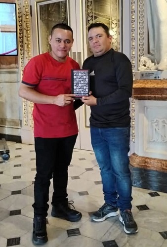 Carlos Jarquín y Eduardo Torres Madrigal, muestran la portada de un poemario de la autoría del poeta guatemalteco Rodrigo Villalobos Fajardo