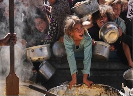 Niños palestinos tratan de hacerse con una ración de comida en un reparto de alimentos en Jan Yunis este viernes

