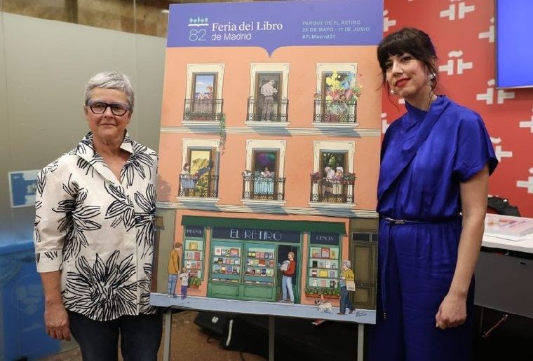 Eva Orúe, directora de la Feria del Libro de Madrid, y María Simavilla, la autora, posan junto al cartel
