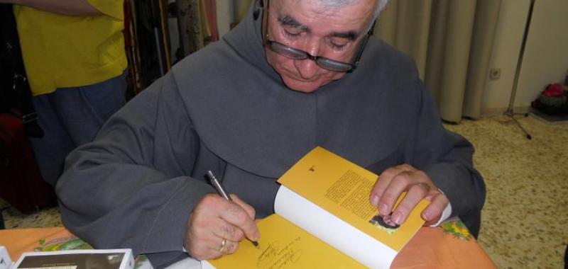 Padre Patera firmando libros